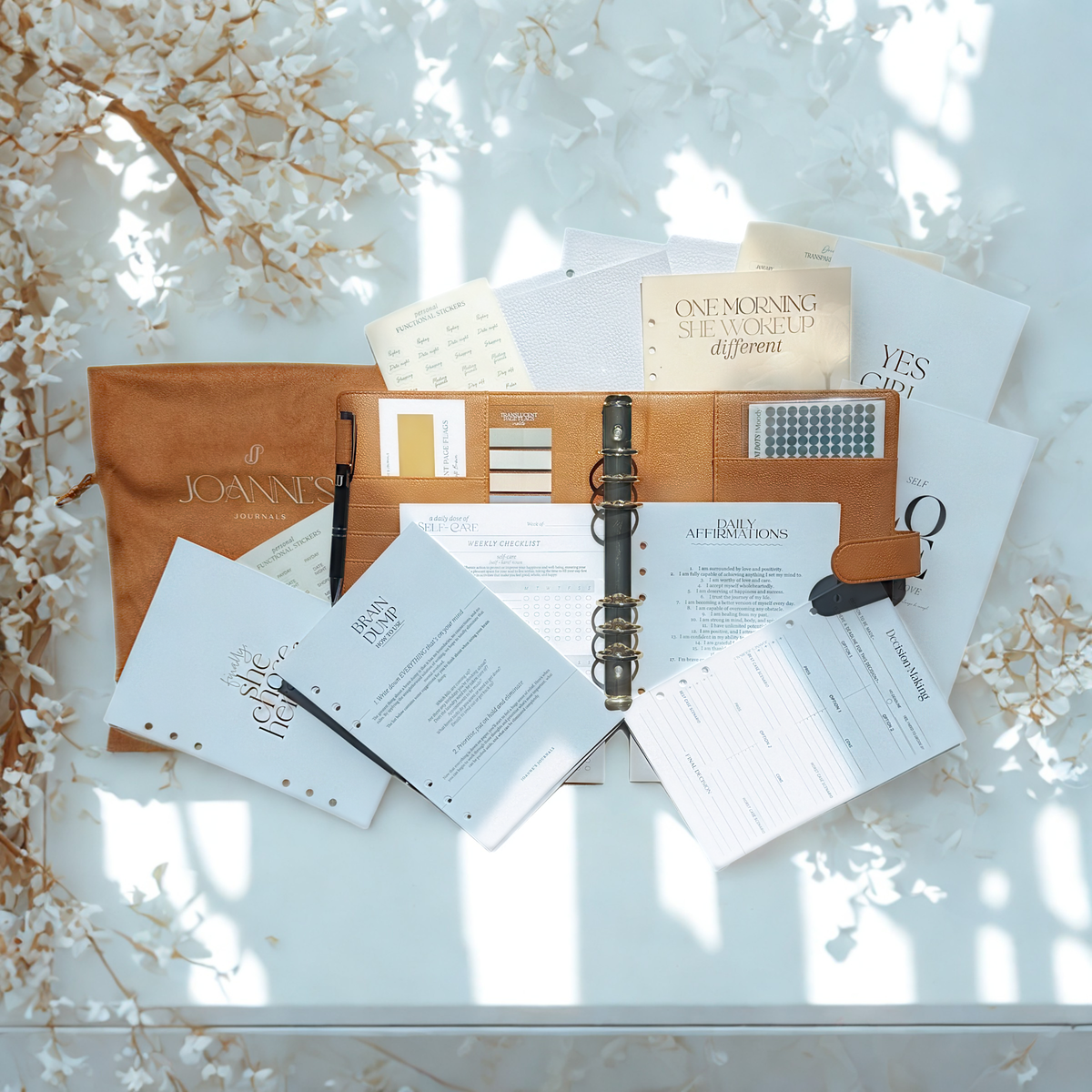 “Flat lay of a wellness planner, pen, stickers, and calming accessories on a desk.”
