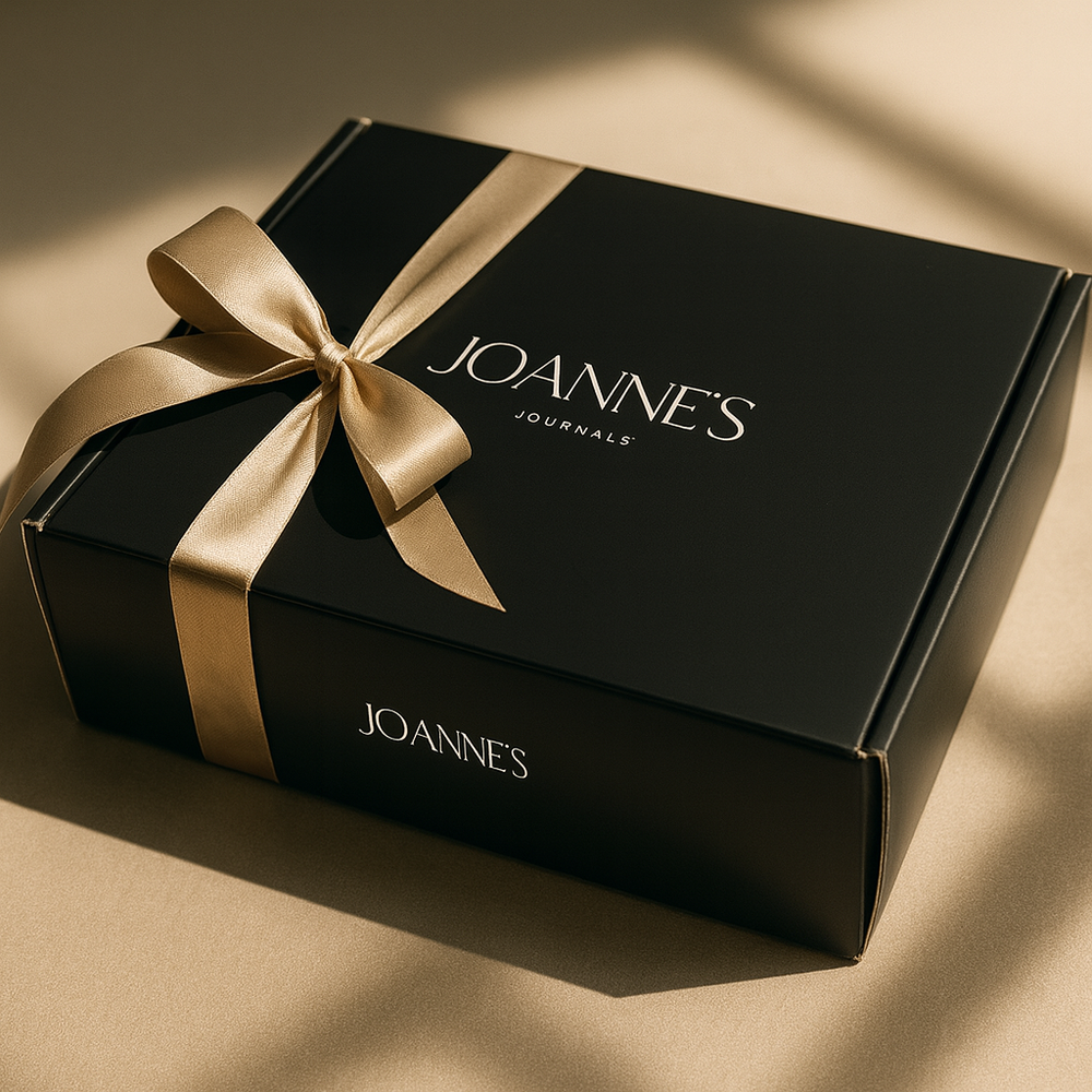 Joanne’s Journals black gift box tied with a champagne ribbon